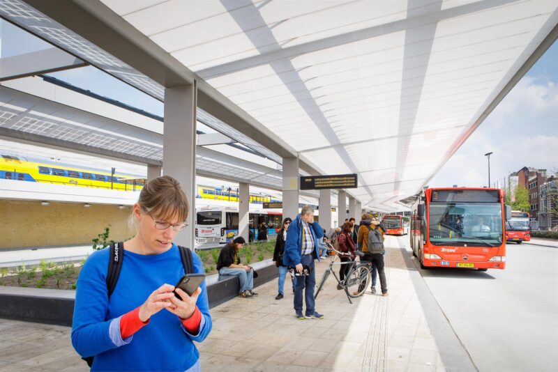 Vrouw op station met mobiel